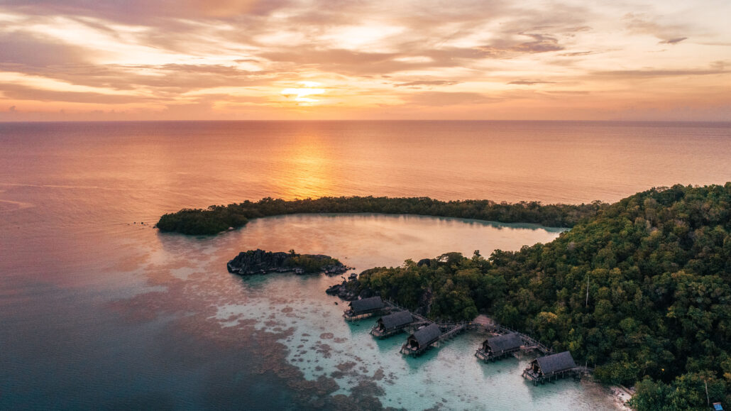 aerial overwater suite sunset with setigi reef background