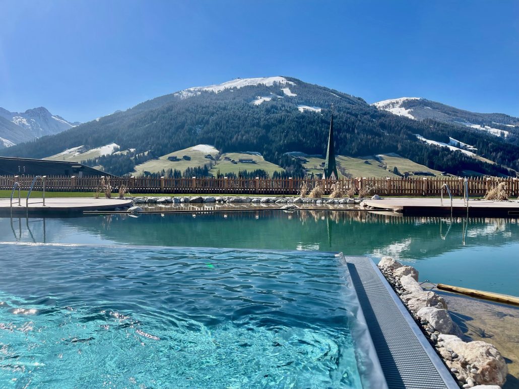infinity pool mit anliegendem badesee der boeglerhof