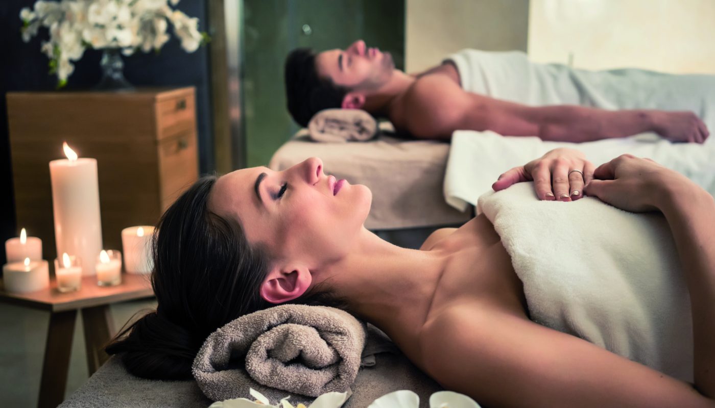 Young man and woman lying down on massage beds at Asian luxury spa and wellness center