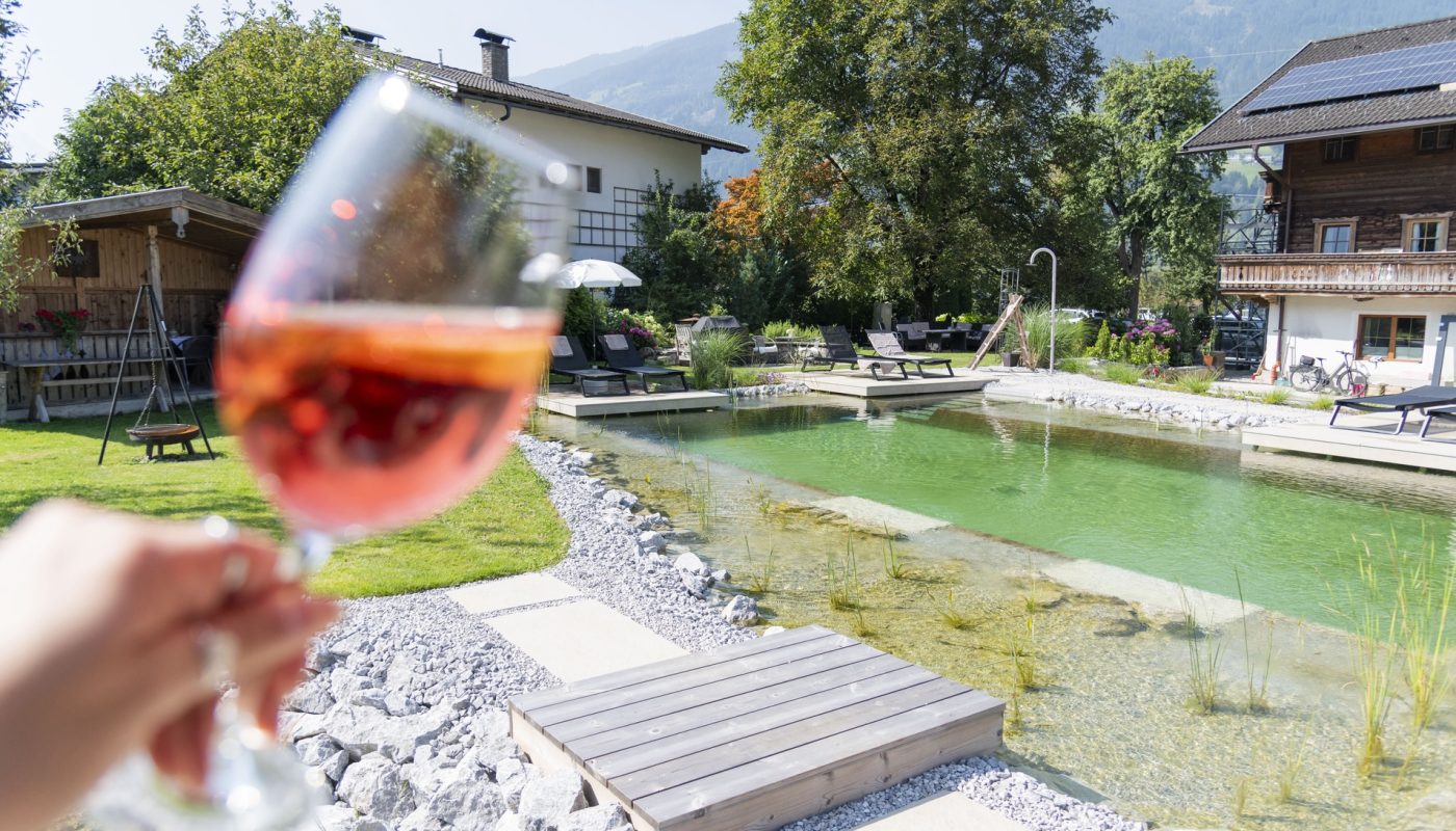 Ein-Glaeschen-am-Naturbadeteich-geniessen-c-Sarah-Edinger-Zillertaler-Hofchalets